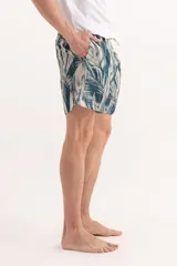 Short de baño con estampado de hojas tropicales en tonos verdes y detalles en naranja. Cuenta con cintura elástica con cordón ajustable.