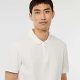 Remera polo blanca de piqué con cuello clásico, manga corta y cierre frontal con cremallera metálica.