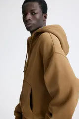 Campera con capucha H&M de corte oversized, color marrón, con cierre frontal y bolsillos tipo canguro.