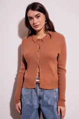 Cardigan marrón de punto acanalado con cuello polo, manga larga y cierre frontal con botones.