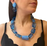 Collar de resina azul con piezas rectangulares y detalles dorados.