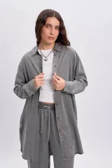 Camisa de jean de corte oversize y largo tipo túnica en color gris desgastado, con mangas largas, cuello camisero y cierre frontal de botones.