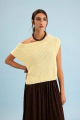 Chaleco de tejido de punto en color amarillo claro, con escote bote amplio que permite usarlo con un hombro al descubierto, de corte holgado y sin mangas.