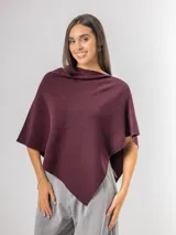 Poncho de corte holgado y diseño minimalista, confeccionado en tejido liviano de color beige, con cuello redondo y caída fluida.