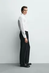 Camisa regular fit de algodón con diseño de rayas finas celestes y blancas. Cuenta con cuello abotonado, manga larga con puños abotonados y cierre frontal de botones.