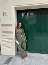 Conjunto gris melange confeccionado en lanilla, compuesto por una remera de manga larga con diseño cruzado en el frente y un pantalón largo de corte ancho con bolsillos.