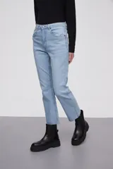 Pantalon jean de corte flare, tiro medio, con ruedo desflecado y cierre frontal con botón y cremallera.