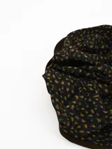 Colita de pelo tipo scrunchie con estampado de puntos irregulares en tonos marrón y negro.