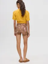 Calza biker de tiro alto con diseño estampado abstracto en tonos marrones, violetas y amarillos. Confeccionada en tejido elástico de lycra.