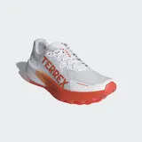 Championes de trail running Adidas Terrex Agravic 3 en color blanco con detalles en naranja. Presentan una mediasuela Lightstrike para amortiguación dinámica, suela de caucho Continental™ con perfil dentado para tracción en senderos y exterior textil transpirable con refuerzos sintéticos resistentes a la abrasión.