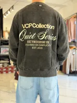 Buzo oversize de cuello redondo, con efecto gastado en tono gris oscuro y gran estampado tipográfico en la espalda.