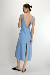 Vestido midi de corte recto con estampado de rayas verticales en tonos azul y blanco. Presenta escote en pico con detalle de abertura ajustable mediante lazada frontal, tirantes anchos con acabado fruncido y cierre lateral con cremallera oculta.