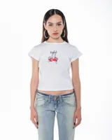 Remera blanca de algodón, corte cropped y mangas cortas. Estampado frontal de dos cerezas rojas atadas con un lazo gris.