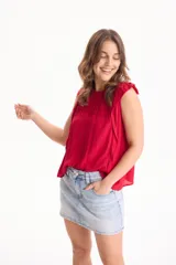 Blusa de viscosa negra sin mangas, con diseño fluido, cuello redondo y detalles de tablas verticales en el pecho con terminaciones de encaje en las sisas.