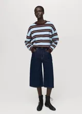 Sweater de punto fino con diseño oversize y estampado de rayas horizontales en tonos marrón, celeste y blanco. Presenta cuello redondo y mangas largas.