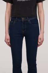 Pantalón jean de corte skinny y tiro medio, con diseño clásico de cinco bolsillos y costuras reforzadas.
