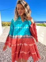 Vestido camisero corto con estampado batik en tonos turquesa y terracota con detalles dorados, cuello mao y mangas 3/4 acampanadas.
