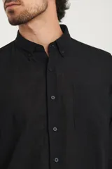 Camisa de manga larga con cuello abotonado y bolsillo frontal, confeccionada en una mezcla de algodón y lino.