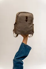 Mochila negra de tela impermeable con detalles en cuero marrón.