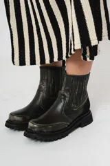 Botas de cuero negro con elásticos laterales, detalle de gamuza en el talón y suela de goma con plataforma.