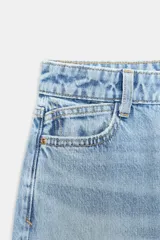 Jeans de denim azul claro lavado, tiro alto, corte Mom Fit con pierna recta y largo tobillero. Presenta cinco bolsillos y cierre frontal con cremallera y botón.
