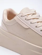 Zapatillas acordonadas color marrón con base de plataforma blanca y recortes texturizados.