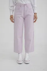 Pantalón de jean color amarillo pastel, de corte recto y tiro medio, con diseño de cinco bolsillos y cierre frontal con botón y cremallera.