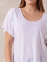 Remera blanca de lino con mangas cortas y fruncido en los hombros.