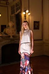 Musculosa corta de cuero color blanco, sin mangas, con ribete decorativo de nácar en las sisas y el ruedo.