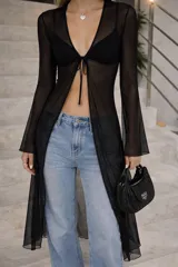 Top largo de tul negro con mangas largas acampanadas, escote en V con cierre de lazo frontal y diseño semitransparente.