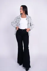 Jeans tiro alto de denim negro, diseño ajustado en la cintura y los muslos, con corte acampanado desde la rodilla hacia el dobladillo.