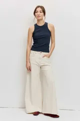 Pantalón denim de corte wide leg, tiro alto y color crudo con costuras en contraste.