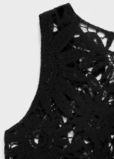 Top sin mangas de crochet con diseño floral calado, cuello redondo y cierre de botón en la parte posterior.