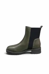 Bota tipo chelsea de cuero sintético marrón, con paneles laterales elásticos negros, costuras visibles en contraste y suela track gruesa de goma negra con tacón bajo.