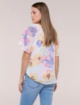 Blusa blanca de doble capa de gasa con estampado floral en tonos amarillos, celestes y rosados, escote en V con frunces y mangas cortas con volados amplios.