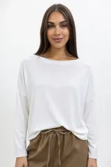 Buzo de lanilla color blanco, con cuello redondo, mangas largas y corte holgado.