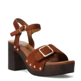 Sandalias de tacón alto Miss Carol modelo Torino, confeccionadas en gamuza marrón. Presentan plataforma con efecto de madera, taco ancho y tira en el empeine con hebilla metálica dorada y tachas decorativas. Incluyen tira ajustable al tobillo con hebilla.