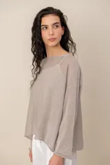 Sweater de tejido semitransparente color marrón con brillo dorado, cuello bote y mangas largas de corte holgado.
