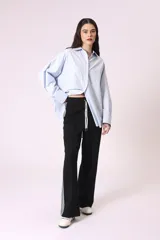 Camisa celeste de corte amplio, con cuello clásico, mangas largas y bolsillo en el pecho.