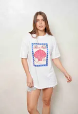 Remeron blanco de algodón, de corte oversize, con mangas cortas y estampa frontal estilo postal con una concha marina rosa y la inscripción 'La Dolce Vita'.