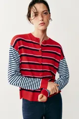 Chaqueta de punto con cuello redondo y mangas largas, con diseño de rayas horizontales en colores rojo, celeste y azul marino, y cierre frontal con botones.
