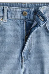 Pantalón de jean celeste de tiro alto, corte ancho y recto, con cinco bolsillos y cierre con botón.