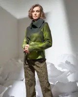 Chaqueta de lana merino afieltrada color verde camuflaje, de corte desestructurado, con cuello alto y tiras para atar en la cintura o cruzar en el cuello.