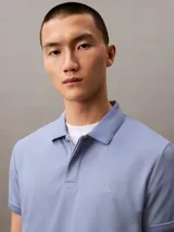Chomba azul de poliéster con monograma de Calvin Klein, corte regular, mangas cortas y cuello polo con cartera de dos botones ocultos.