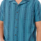 Camisa de manga corta azul con estampado de rayas verticales y motivos geométricos.