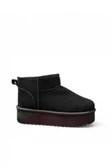 Pantubota corta de gamuza color negro, con plataforma gruesa y suela dentada. Cuenta con presilla en el talón para facilitar el calce.