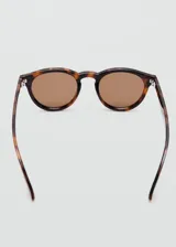 Lentes de sol circulares con montura de carey y cristales marrones.