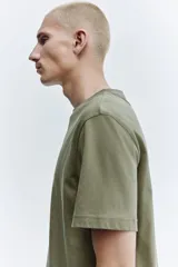 Remera de algodón verde militar con cuello redondo y mangas cortas, de corte estándar.