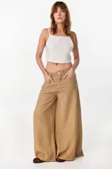 Pantalón de lino verde militar, de tiro alto y corte amplio con botamanga ancha. Cuenta con bolsillos delanteros aplicados y cierre frontal con botón y bragueta.