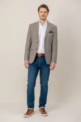Saco de corte custom fit, confeccionado en una mezcla de seda y lana con textura jaspeada en tono marrón claro. Presenta solapas clásicas, cierre frontal de dos botones, bolsillos laterales con solapa y un bolsillo superior con pañuelo decorativo.